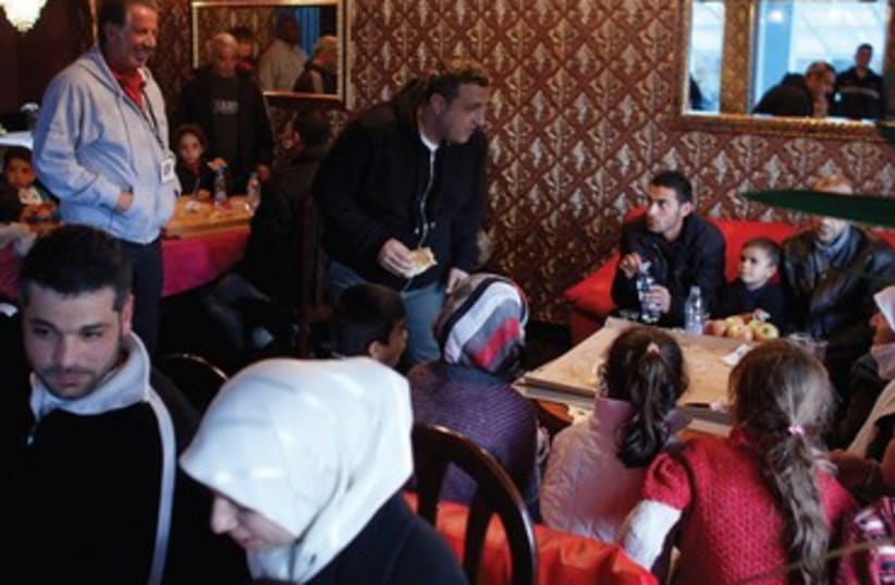 Yank Barry (left standing) with Syrian refugees in Bulgaria. (photo credit: REUTERS)