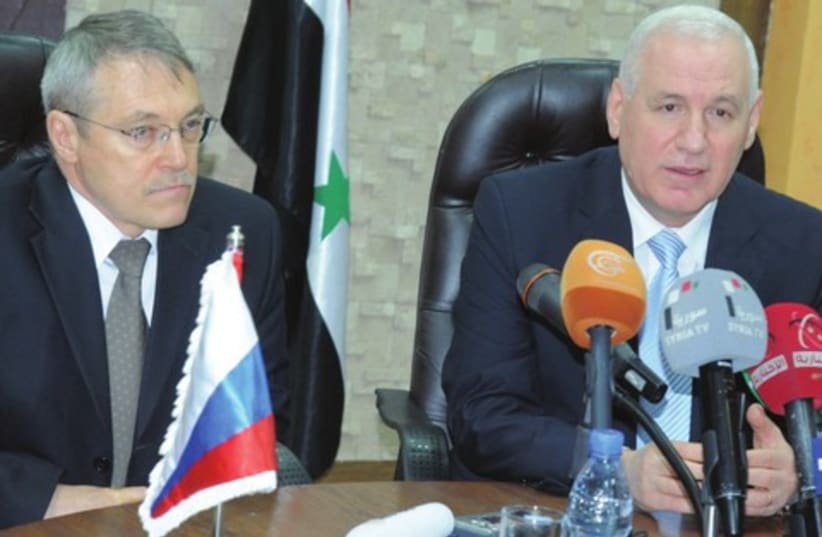 Syrian Oil Minister Suleiman al-Abbas (right) and Russian Ambassador Azmatullah Kulmohamedov in Damascus (photo credit: SANA/REUTERS)