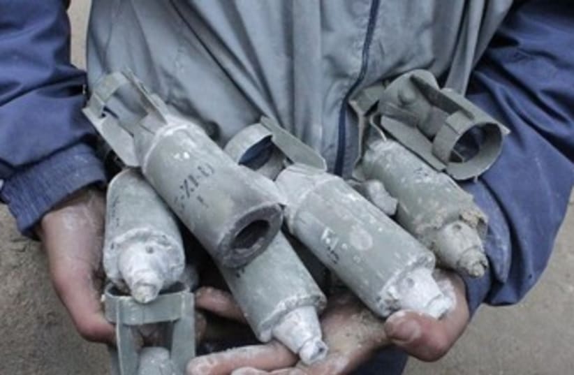 A Syrian boy holds unexploded cluster bombs in Aleppo. (photo credit: REUTERS)