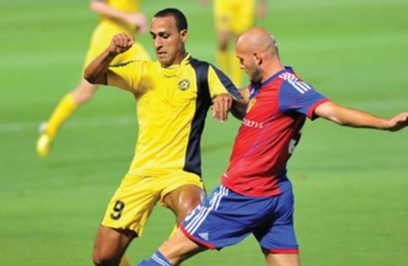 Maccabi Tel Aviv’s Maharan Radi (left) and FC Basel’s Arlind Ajeti (right) are set to resume battle when their teams meet in the Europa League roundof- 32 first leg at Bloomfield Stadium. Basel knocked out Maccabi in the third qualifying round of the Champions League earlier this season.  (photo credit: ASAF KLIGER)