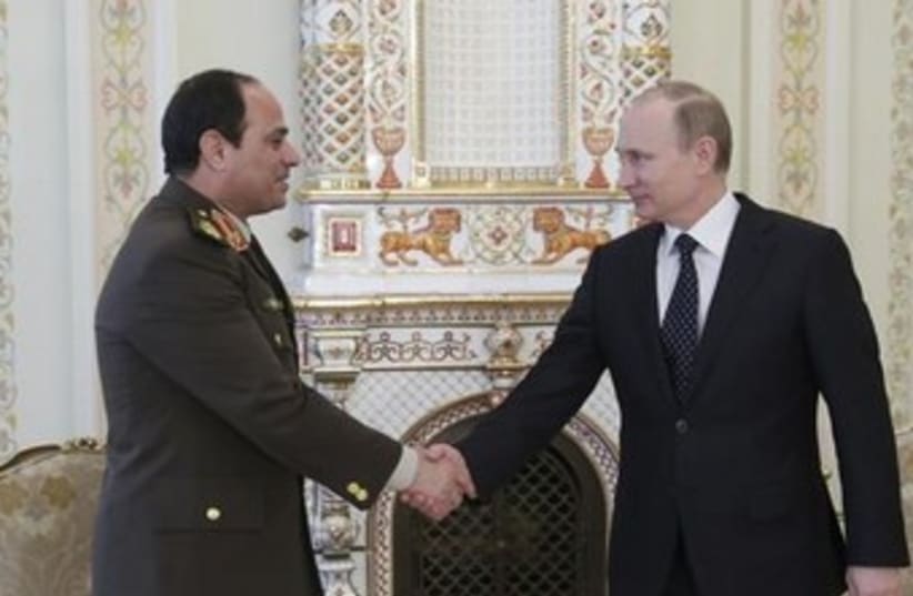 Russian President Vladimir Putin (R) shakes hands with Egypt's Army chief Field Marshal Abdel Fattah al-Sisi. (photo credit: REUTERS)