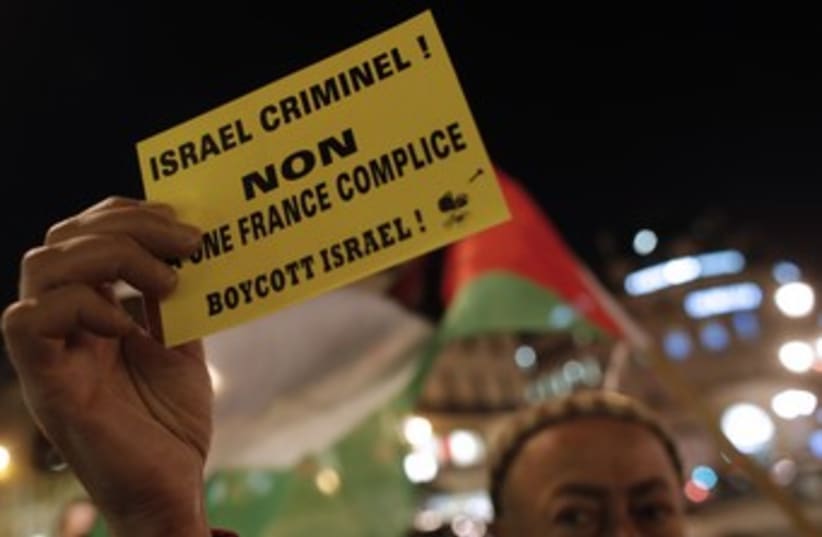 Man holds boycott Israel sign (photo credit: REUTERS/CHRISTIAN HARTMANN)
