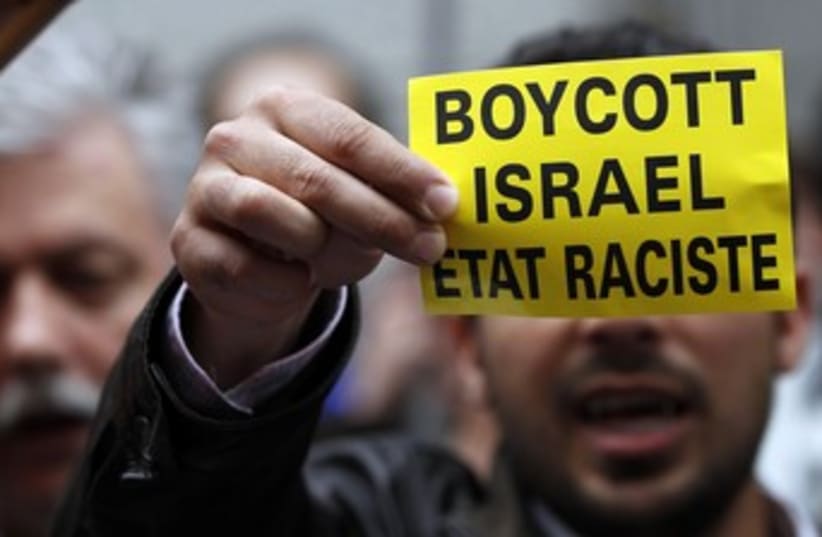 Man holds boycott Israel sign (photo credit: REUTERS/FRANCOIS LENOIR)