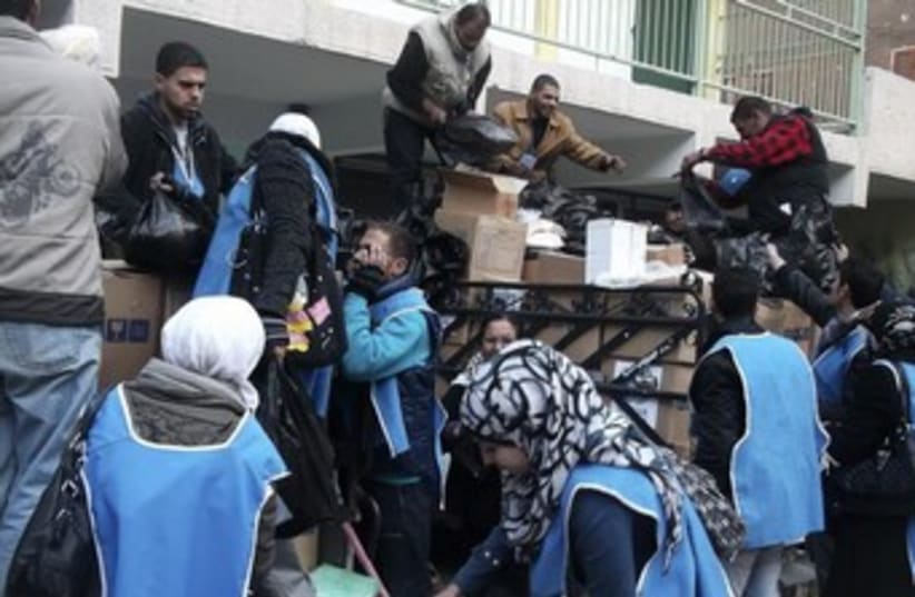 UNRWA workers prepare aid parcels at the Palestinian refugee camp of Yarmouk (photo credit: REUTERS)
