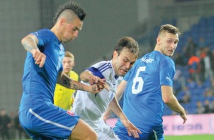 Israel midfielder Bibras Natcho (center) tries to wrestle the ball away from Slovakia’s Marek Hamsik (left). (photo credit: ADI AVISHAI)