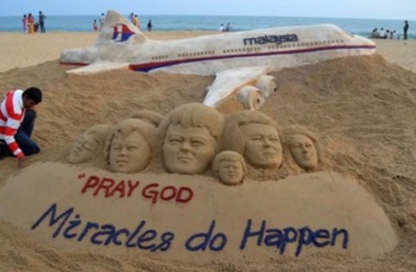 Indian sand artist Sudarshan Patnaik creates a sand sculpture in honor of the passengers. (photo credit: REUTERS)