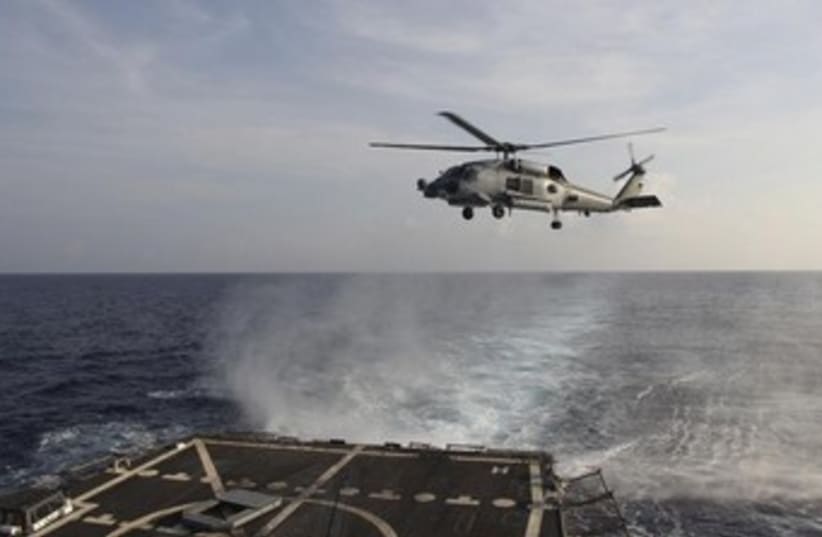 A US Navy helicopter takes off from the USS Pinckney to assist in the search for the missing Malaysia Airlines jet. (photo credit: REUTERS)