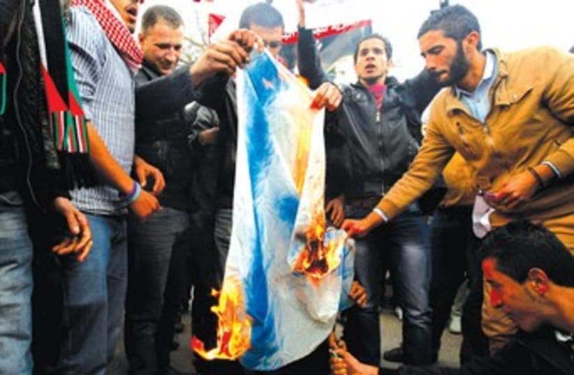 JORDANIANS BURN an Israeli flag in front of the parliament in Amman (photo credit: REUTERS)