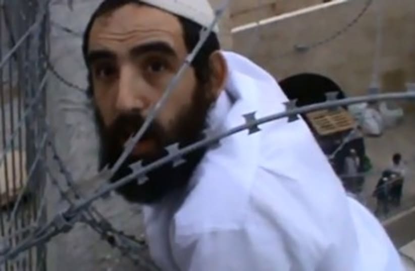 Hebron man caught in barbed wire trying to remove Palestinian flag (photo credit: YOUTUBE SCREENSHOT)