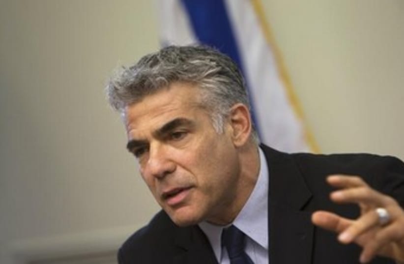 Finance Minister Yair Lapid gestures during a speech to his Yesh Atid deputies at the Knesset. (photo credit: REUTERS)