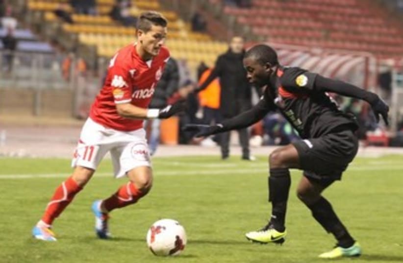 Hapoel Ra’anana and Emmanuel Mbola contained Hapoel Beersheba and Maor Buzaglo (left) to claim a 1-0 victory in Netanya. (photo credit: MEIR EVEN HAIM)