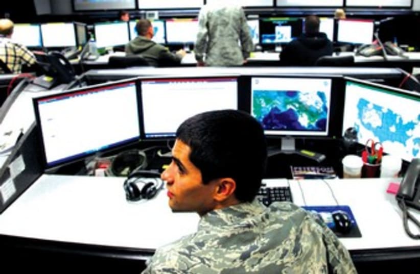 Hapoel SEC.-LT. WILLIAM LIGGETT works at the US Air Force Space Command Network Operations and Security Center in Colorado Springs, Colorado. The Space Command supports US military operations worldwide, in part through cyber operations.guard Yotam Halperin surges past Maccabi Haifa’s Brian Randle du (photo credit: REUTERS)