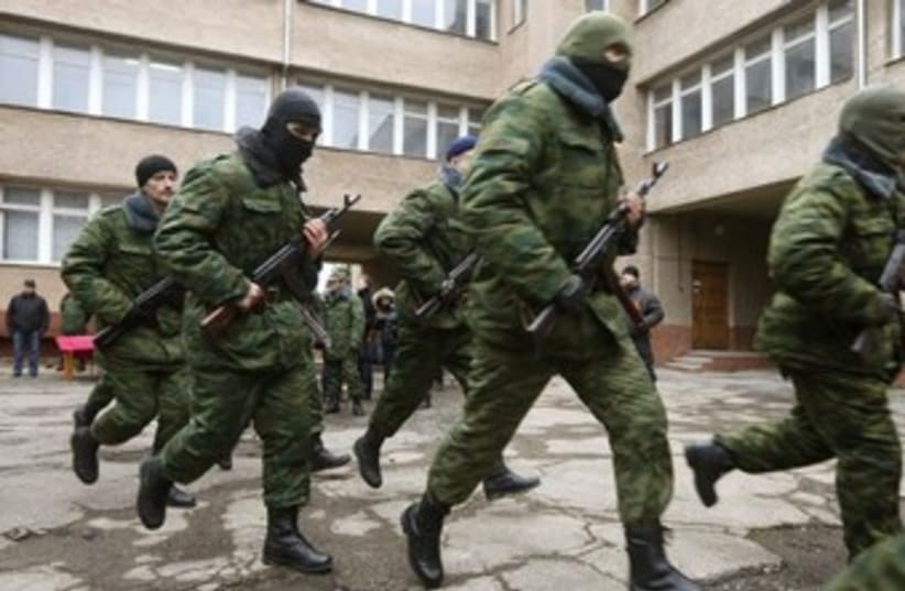 Members of a pro-Russian self defence unit run after taking an oath to Crimea government in Simferopol March 10, 2014. (photo credit: REUTERS)