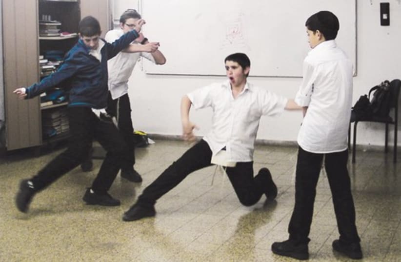 Pupils at the Hanoch Lenar yeshiva act out a soccer game victory as part of a Chasidrama course. (photo credit: RONEN GRIDISH)