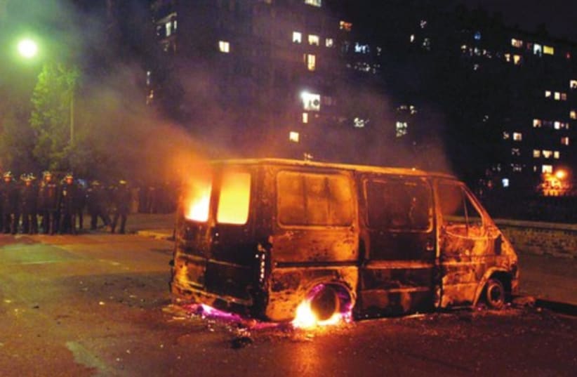 A VAN burns after clashes between French youth and riot police in the Paris suburb of Clichy (photo credit: REUTERS)