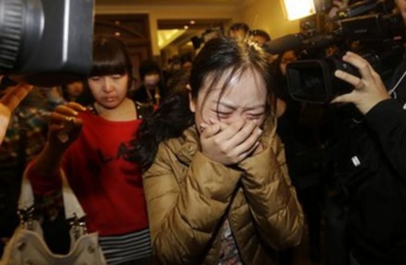 A relative of a passenger on the missing Malaysia Airlines jet grieves in Beijing. (photo credit: REUTERS)