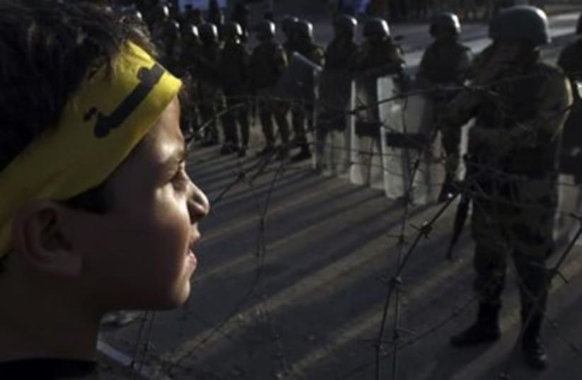 A supporter of the Muslim Brotherhood faces Egyptian police in Cairo. (photo credit: REUTERS)