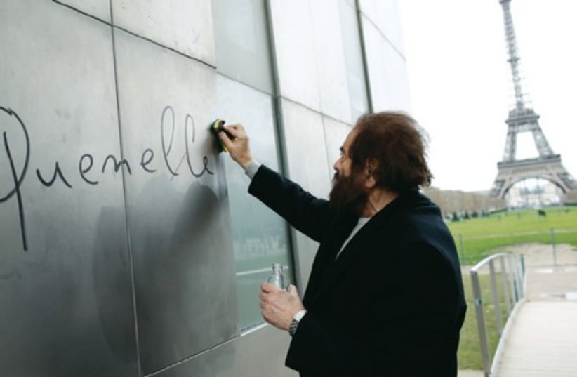 The word ‘quenelle,’ an anti-Semitic reference, is removed from ‘The Wall For Peace’ in Paris. (photo credit: REUTERS)