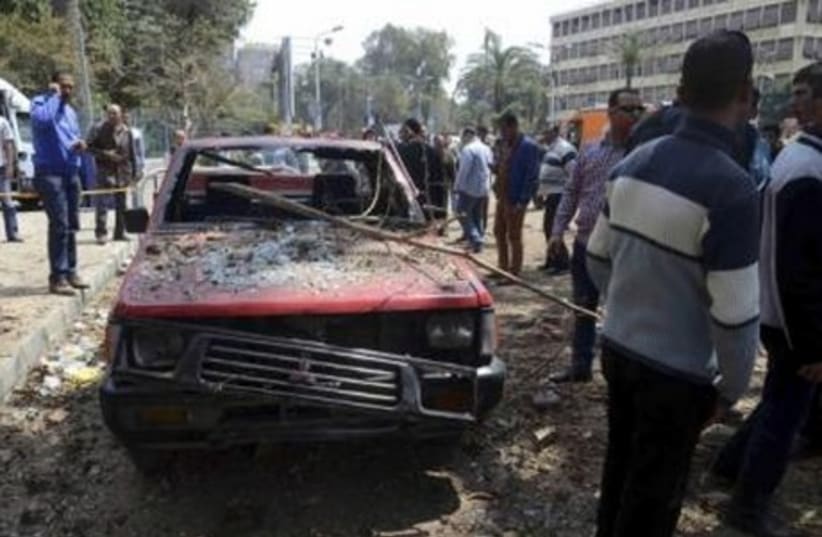 A car damaged by explosions near Cairo University, April 2 (photo credit: REUTERS)