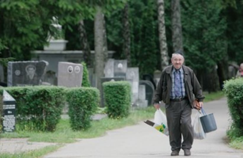 A man walks in the Jewish cemetery near Vilnius. (photo credit: REUTERS)