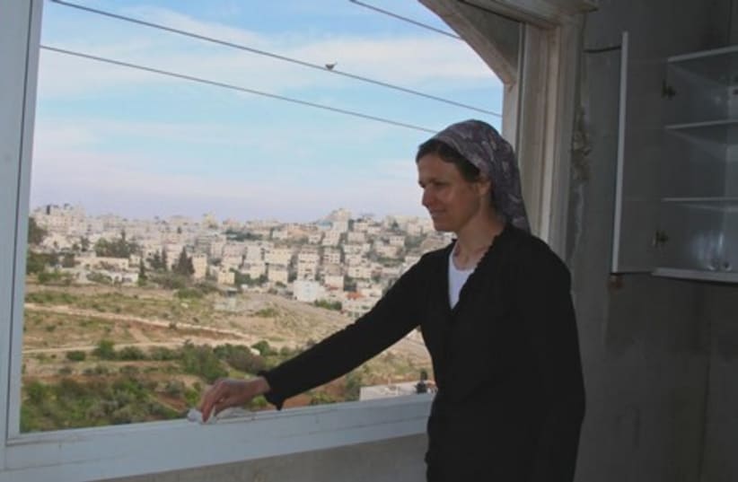 Yisca Levinger dusts her window sill in Beit HaShalom. (photo credit: TOVAH LAZAROFF)