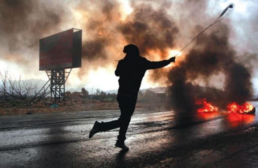 Demonstrator clashes with Israeli troops in the West Bank village of Silwad, January 10 (photo credit: MOHAMAD TOROKMAN/REUTERS)