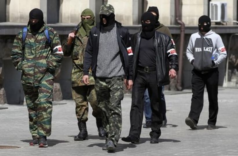 Pro-Russian armed men walk past the mayor's office in Donetsk April 16, 2014.  (photo credit: REUTERS)