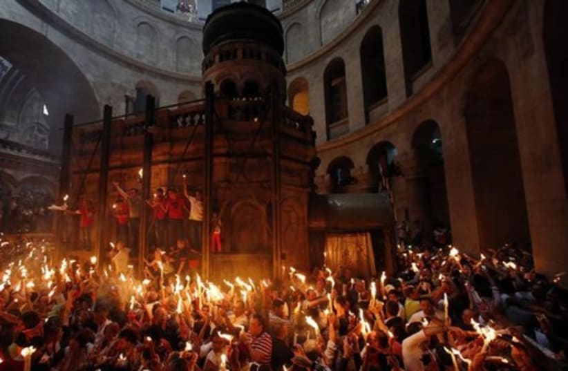 Worshippers take part in the Christian Orthodox Holy Fire ceremony at the Church of the Holy Sepulchre in Jerusalem. (photo credit: REUTERS)