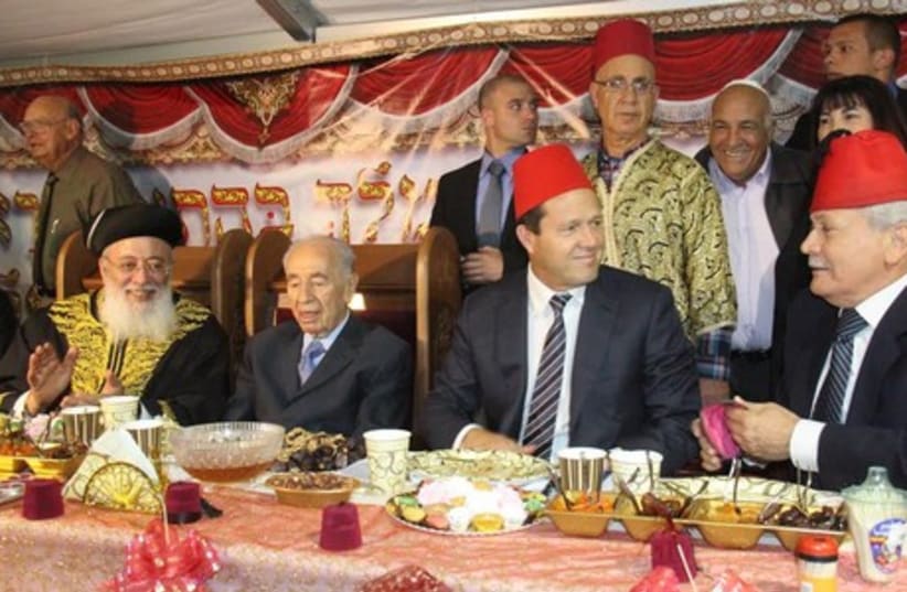 President Shimon Peres (C), former Sephardi chief rabbi Shlomo Amar (L) and Jerusalem Mayor Nir Barkat (R) celebrate Mimouna festivities in Jerusalem. (photo credit: GPO)