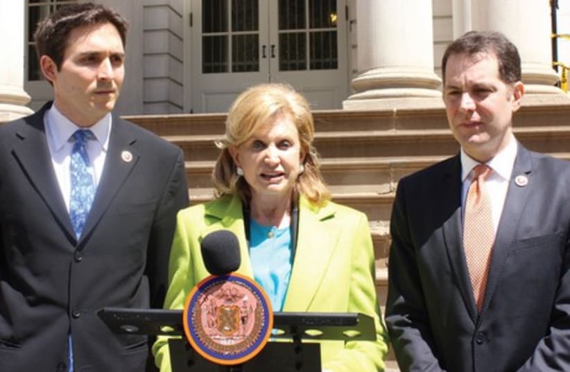 NEW YORK Congresswoman Carolyn B. Maloney, flanked by City Councillors Mark Levine (right) and Benjamin Kallos, announces Monday their intention to pass a resolution to prohibit city enterprises from dealing with companies that profited from the Holocaust and have not paid reparations. (photo credit: MAYA SHWAYDER)