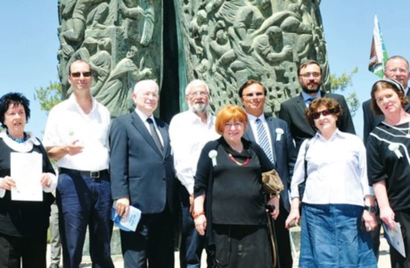 TOVA ECKSTEIN (center, with cane) stands with other participants in front of the Scroll of Fire memorial, yesterday. Her late father, Jonas, was honored for saving 2,000 Jews in the Holocaust. (photo credit: RAFI KOTZ)