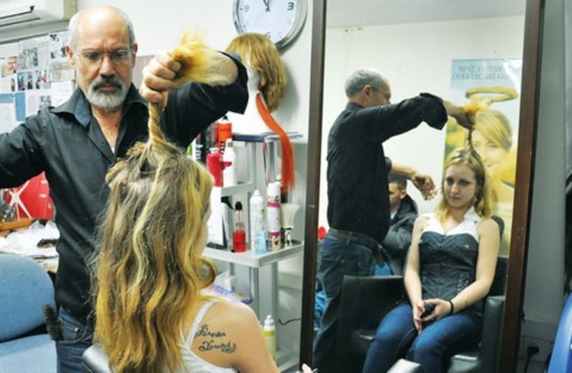 Model Katia Marshvin has her locks cut by Eli Ben-Zikri to use as a wig while she undergoes treatment. (photo credit: Courtesy)