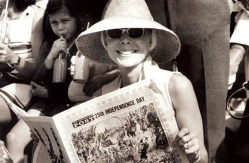 A WOMAN holds a copy of ‘The Jerusalem Post’s Independence Day Supplement during a celebration of the country’s 25th year. (photo credit: JERUSALEM POST ARCHIVE)