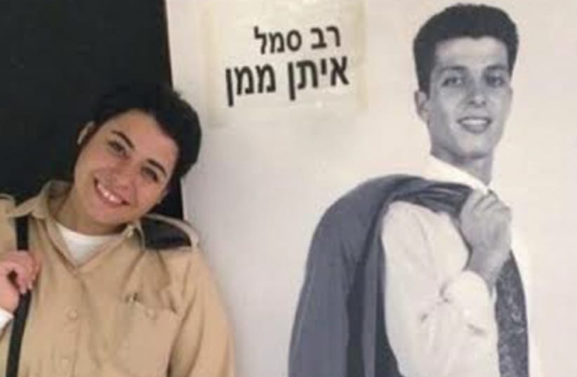 Eden Maman, head of human resources at Tel Nof Air Base, stands next to a life-size picture of her father, who was killed in a helicopter crash in Lebanon. (photo credit: IDF SPOKESMAN'S OFFICE)