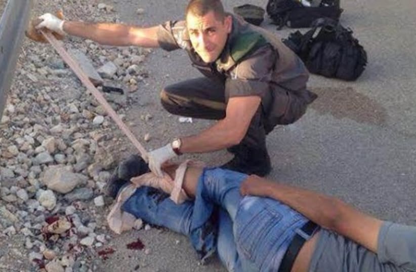 A Border Police medic treats an injured Palestinian would-be infiltrator. (photo credit: COURTESY ISRAEL POLICE)