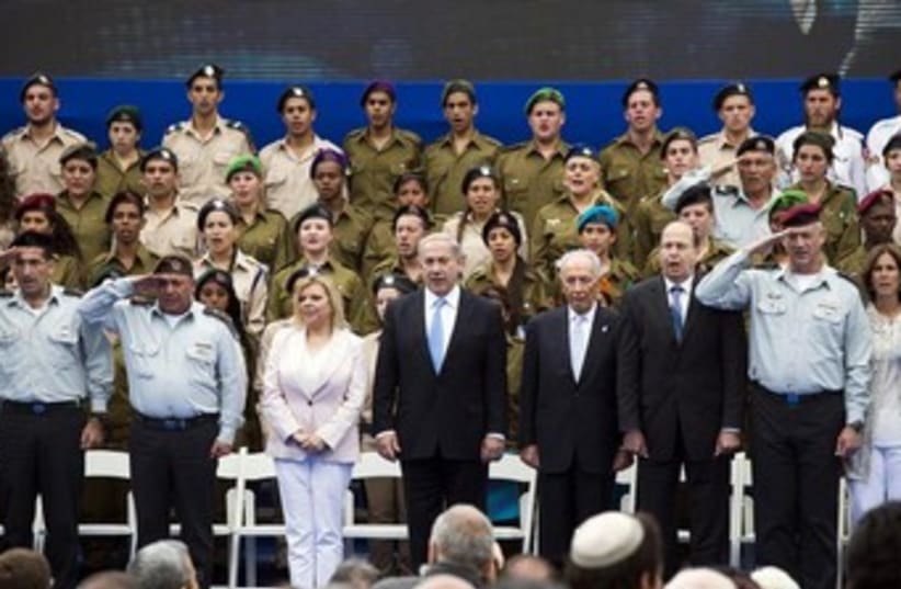 Israeli Prime Minister Benjamin Netanyahu (front row, 4th L), his wife Sara (3rd L), Israeli President Shimon Peres (4th R), Defence Minister Moshe Yaalon (3rd R), Army chief Benny Gantz (2nd R), and Gantz's wife Revital Gantz (R) sing the national anthem at an event to commemorate outstanding soldi (photo credit: REUTERS)