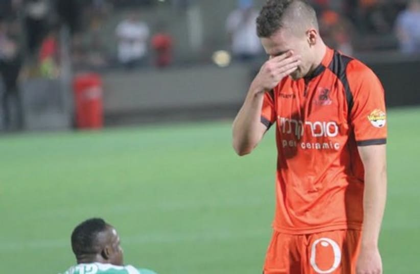  Bnei Yehuda forward Amir Agajev (right) left the pitch in tears Saturday night after his team was relegated from the Premier League. (photo credit: ADI AVISHAI)