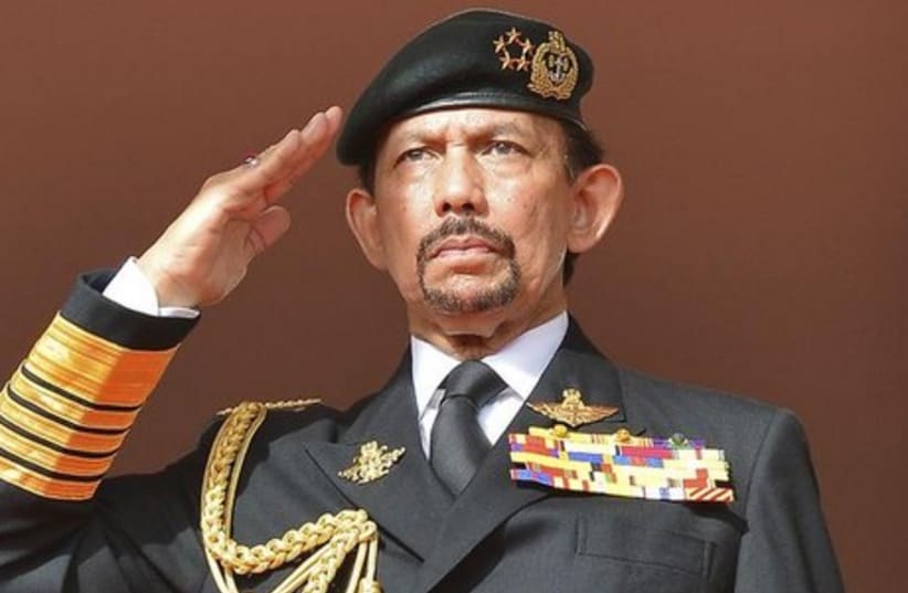 Brunei's Sultan Hassanal Bolkiah salutes as the national anthem is played during celebrations for Brunei's 30th National Day in Bandar Seri Begawan. (photo credit: REUTERS)