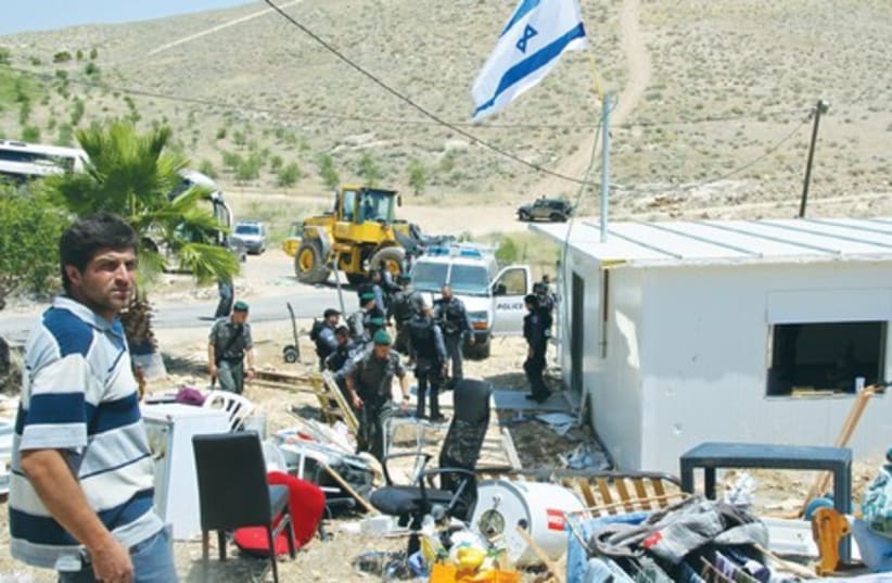 CHONI KANIEL (left) stands beside his belongings as security forces get ready to bulldoze his home in the Ma’aleh Rehavam outpost, in the Gush Etzion region of the West Bank, yesterday. (photo credit: TOVAH LAZAROFF)
