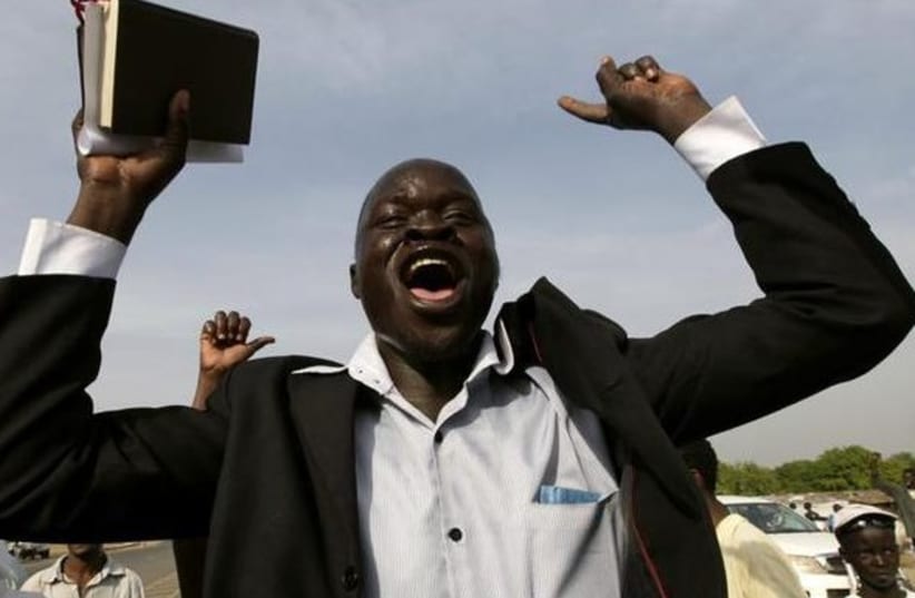A Christian holds up a bible as he chants slogans during a parade in support of the referendum on south Sudan independence in Juba. (photo credit: REUTERS)