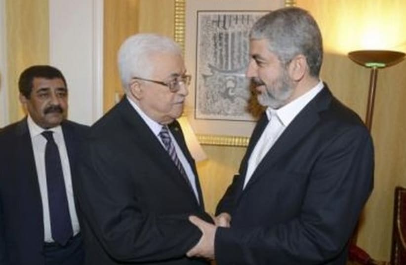 Palestinian President Mahmoud Abbas (L) shakes hands with Hamas chief Khaled Mashaal in Doha May 5, 2014. (photo credit: REUTERS)