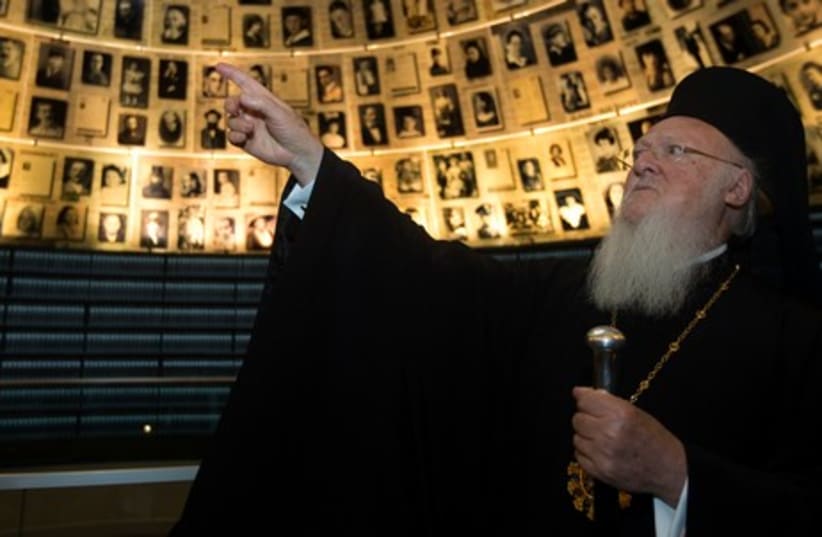 Ecumenical Orthodox Patriarch Bartholomew I of Constantinople looks at pictures of Jews killed in the Holocaust during a visit to Yad Vashem, May 27, 2014. (photo credit: REUTERS)