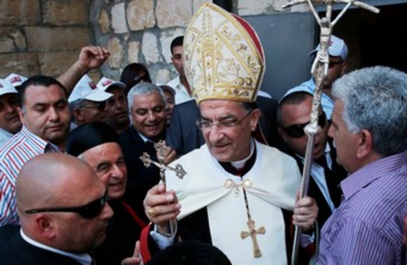 Maronite Patriarch Beshara al-Rai (C) holds a cross during his visit to Birim, a northern Israeli village, May 28, 2013 (photo credit: REUTERS)