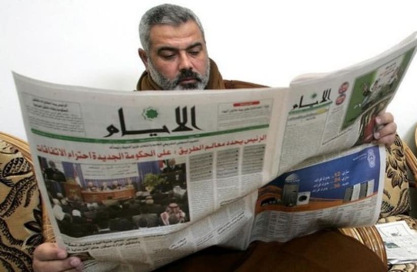 Hamas leader Ismail Haniyeh reads a newspaper. [File] (photo credit: REUTERS)