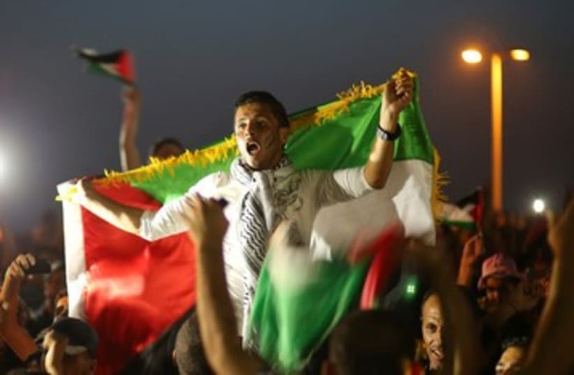 Palestinians celebrate after their national soccer team defeated the Philippines during their AFC Cup final soccer match, in Gaza City May 30, 2014 (photo credit: REUTERS)