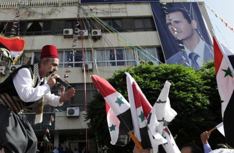 Supporters of Syria's President Bashar Assad wave the national flags and chant slogans in Damascus, June 3, 2014.  (photo credit: REUTERS)