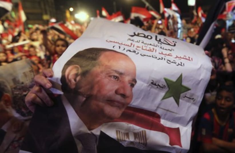 Egyptians gather outside the presidential palace to celebrate former Egyptian army chief Abdel Fattah al-Sisi's victory in the presidential vote in Cairo, June 5, 2014. (photo credit: REUTERS)