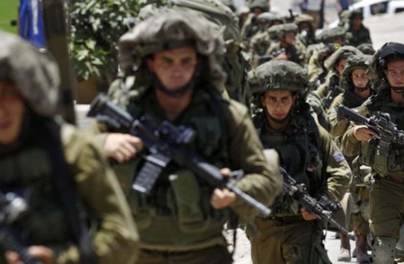 Israeli soldiers patrol near the West Bank City of Hebron June 15, 2014. (photo credit: REUTERS)