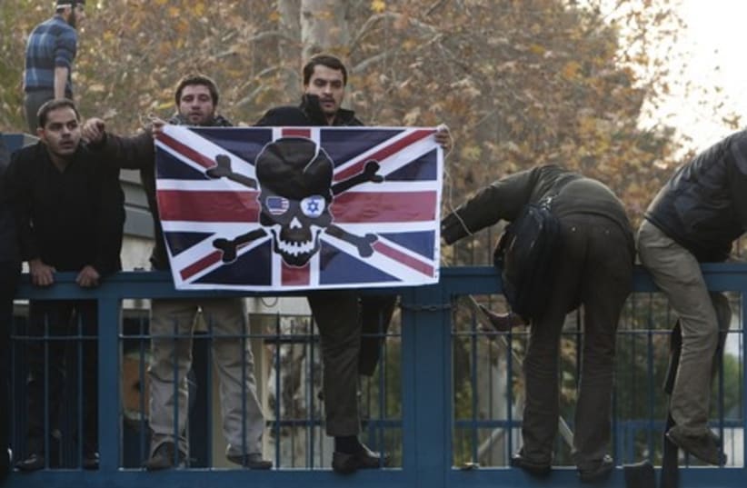 Iranian protesters climb over the gate of the British embassy in Tehran November 29, 2011. (photo credit: REUTERS)