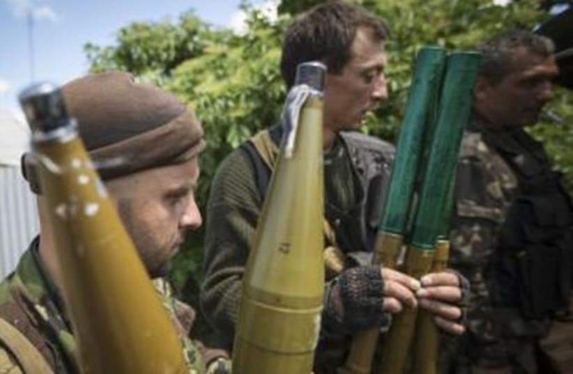 Pro-Russian separatists hold rocket-propelled grenade (RPG) projectiles as they get ready to go to the battle line in Seversk (Siversk), located near the town of Krasny Liman, Donetsk region, June 19, 2014 (photo credit: REUTERS)